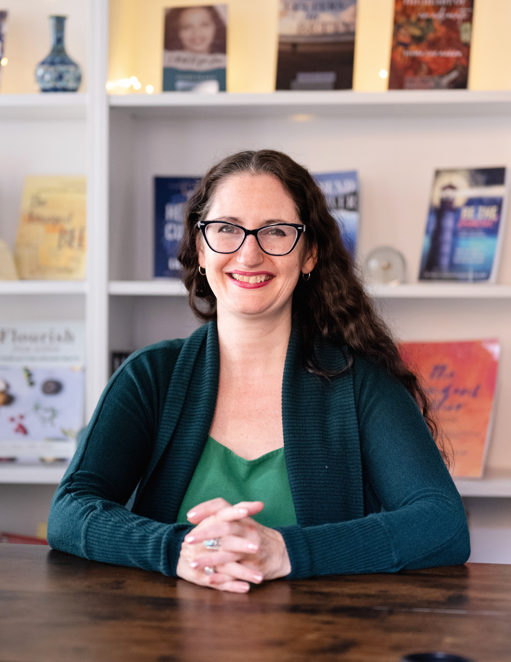Headshot of Elizabeth Hill with a handful of books Headshot of Elizabeth B. Hill, MSW in front of books published by Green Heart Living Press